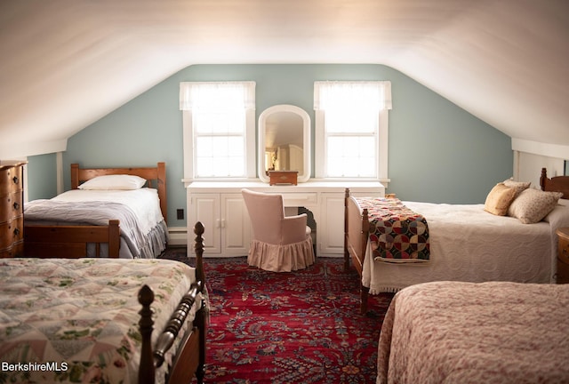 carpeted bedroom with a baseboard radiator and vaulted ceiling