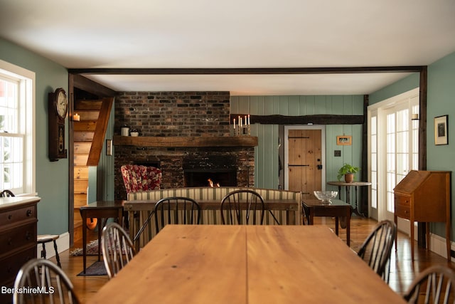 dining area with a brick fireplace and wood finished floors