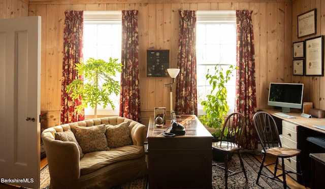 sitting room featuring a wealth of natural light and wooden walls