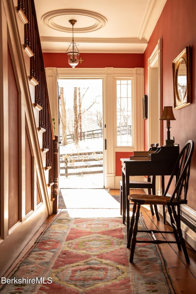 doorway to outside featuring a notable chandelier, stairway, and crown molding