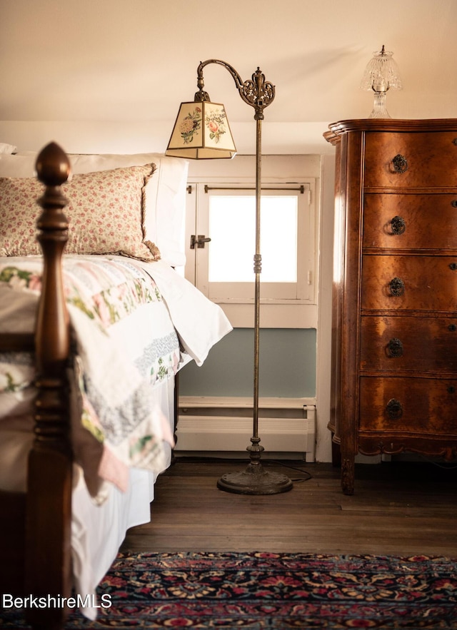 bedroom featuring dark wood finished floors and baseboard heating