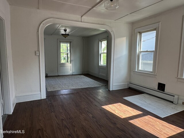287 Houghton St, North Adams, MA 01247 - empty room featuring arched walkways, a baseboard radiator, dark wood-style floors, and a baseboard heating unit