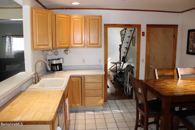 kitchen featuring light brown cabinetry, sink, light tile patterned floors, and ornamental molding