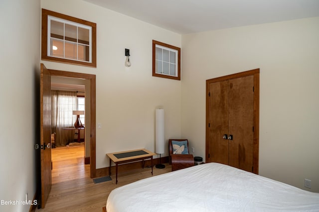 bedroom featuring a closet, baseboards, and wood finished floors