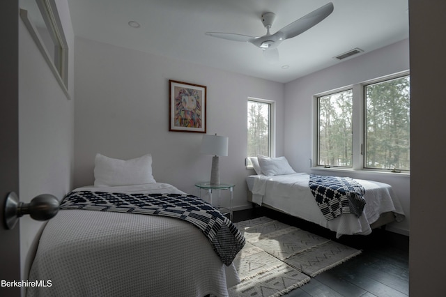 bedroom featuring visible vents, ceiling fan, baseboards, and hardwood / wood-style flooring