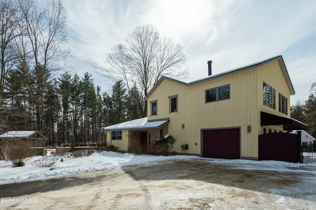 exterior space featuring a garage, dirt driveway, and fence