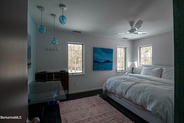 bedroom featuring baseboards, multiple windows, and visible vents