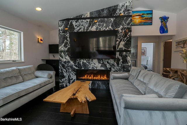 living room featuring recessed lighting, vaulted ceiling, wood finished floors, and a high end fireplace