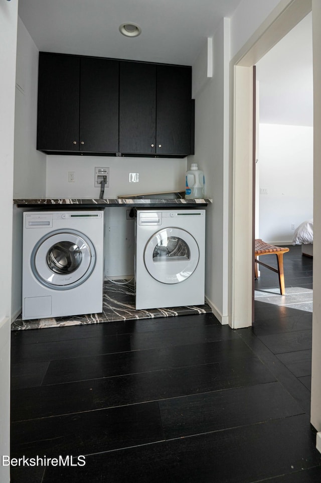 laundry area featuring cabinet space, dark wood-style flooring, and washing machine and clothes dryer