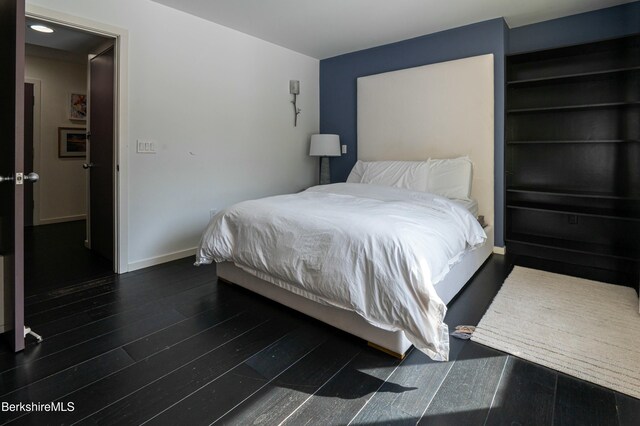 bedroom featuring wood finished floors and baseboards