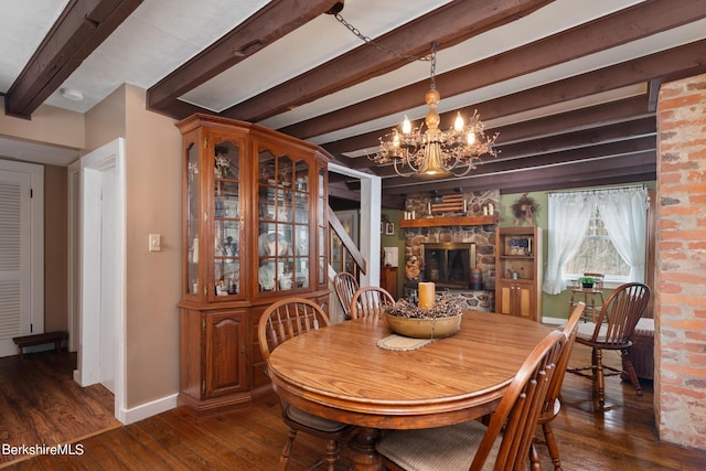 dining space with a chandelier, beam ceiling, a fireplace, and dark wood-type flooring