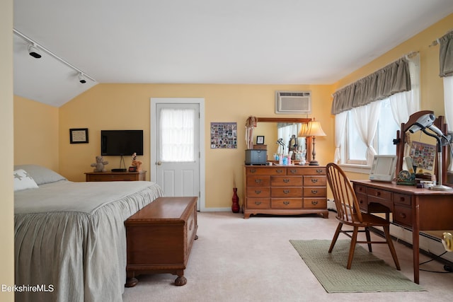 bedroom with light colored carpet, multiple windows, a wall unit AC, and track lighting