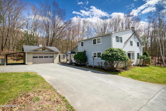 view of front of property featuring a carport, a garage, and a front yard