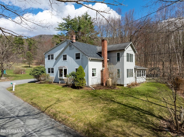 view of front of property featuring a mountain view and a front lawn