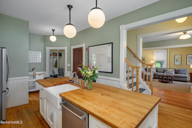 163 Cole Ave, Williamstown, MA 01267 - kitchen with wooden counters, appliances with stainless steel finishes, white cabinets, and wainscoting