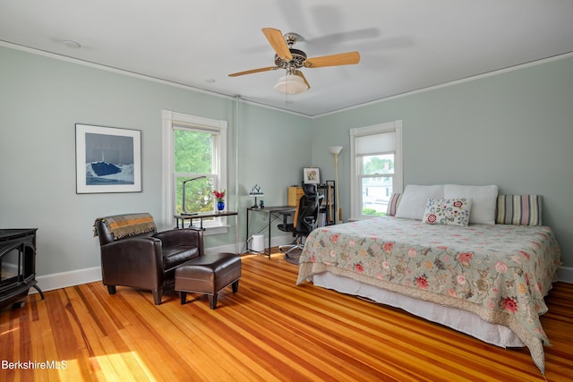 163 Cole Ave, Williamstown, MA 01267 - bedroom featuring a wood stove, crown molding, wood finished floors, and ceiling fan