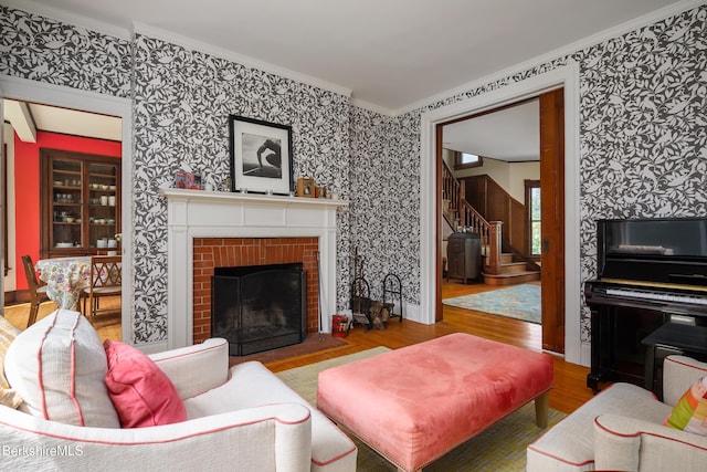 163 Cole Ave, Williamstown, MA 01267 - living room with crown molding, wallpapered walls, wood finished floors, stairs, and a fireplace