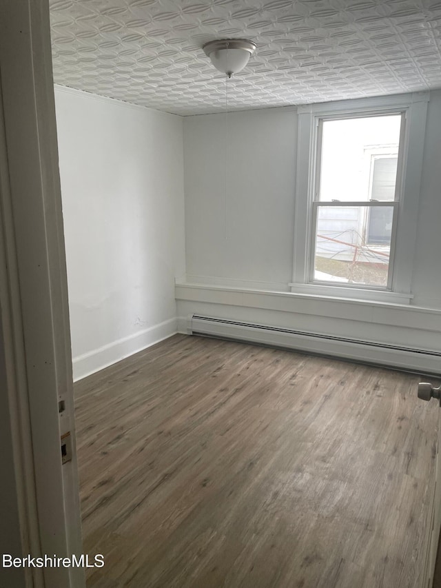 23-27 Gallup St, North Adams, MA 01247 - empty room with baseboard heating, wood finished floors, and an ornate ceiling