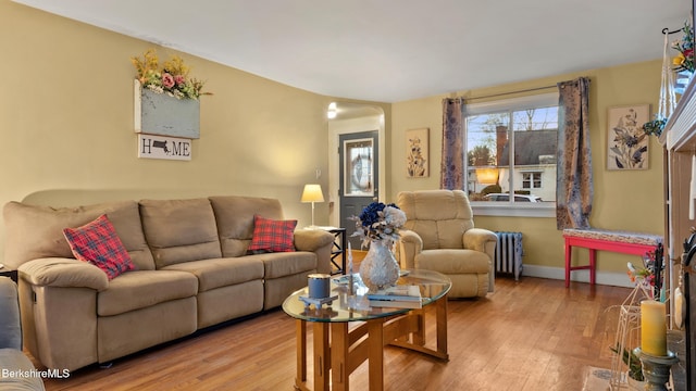 living room featuring wood-type flooring and radiator heating unit