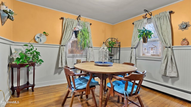 dining room featuring baseboard heating and hardwood / wood-style flooring