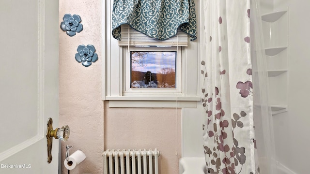 bathroom with shower / tub combo with curtain and radiator heating unit