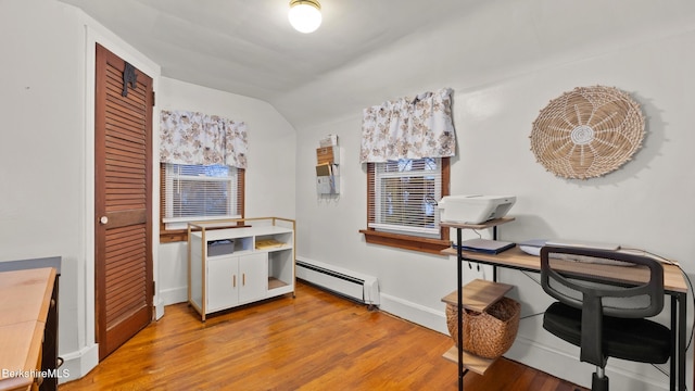 office space with a baseboard radiator, vaulted ceiling, and light hardwood / wood-style flooring