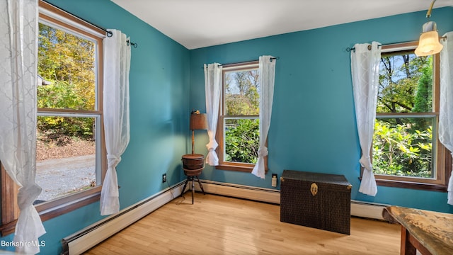 living area featuring light hardwood / wood-style floors and a baseboard heating unit