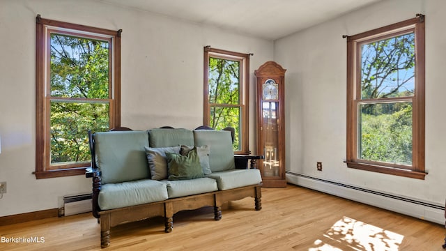 living area with light wood-type flooring and a baseboard radiator