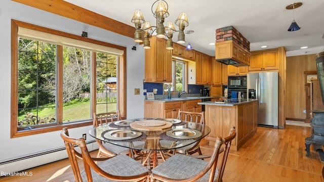 kitchen with black appliances, sink, decorative light fixtures, a notable chandelier, and a kitchen island