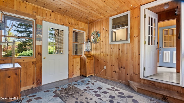 doorway to outside with wood walls and wooden ceiling