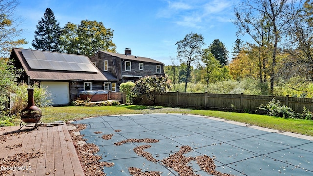 view of swimming pool with a lawn and a hot tub