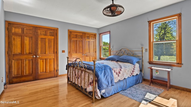 bedroom featuring multiple closets and light hardwood / wood-style flooring