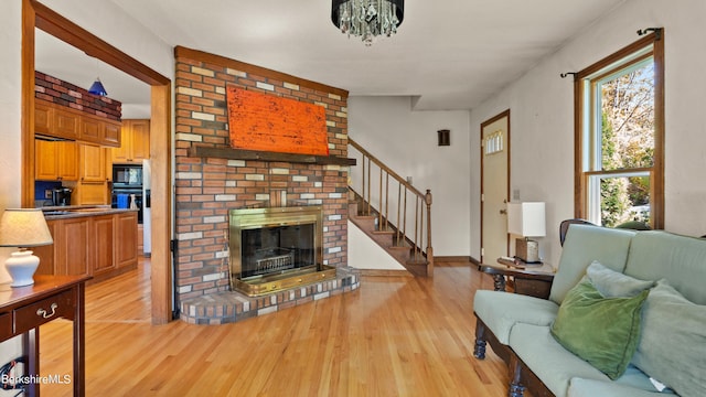 living room with a wealth of natural light, a fireplace, and light hardwood / wood-style floors