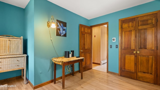 hallway with baseboard heating and light wood-type flooring