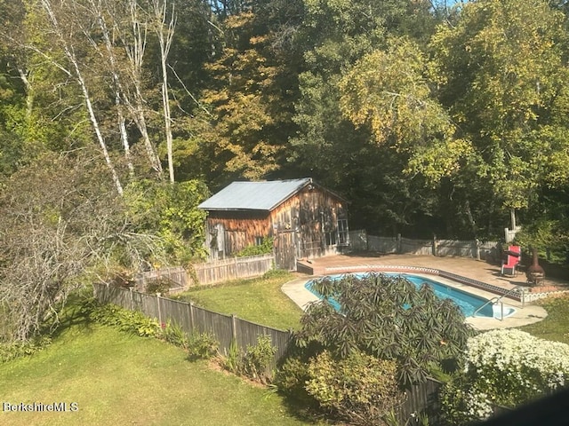 view of pool with a lawn and an outdoor structure