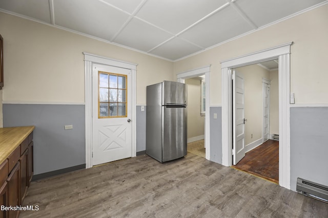 kitchen featuring hardwood / wood-style flooring, stainless steel fridge, and a baseboard radiator