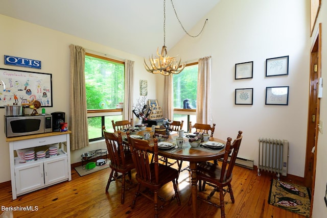 303 Lakeshore Dr, Sandisfield, MA 01255 - dining area featuring radiator, a chandelier, light wood finished floors, vaulted ceiling, and healthy amount of natural light