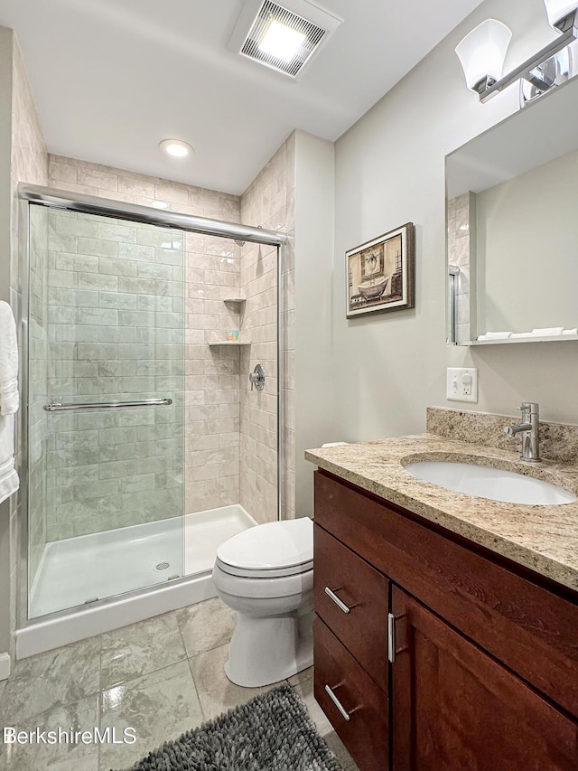 bathroom featuring walk in shower, tile patterned floors, vanity, and toilet