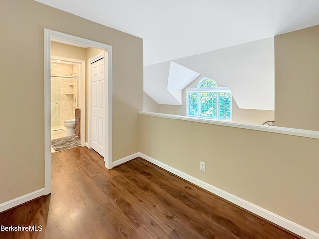 bonus room with hardwood / wood-style floors and vaulted ceiling