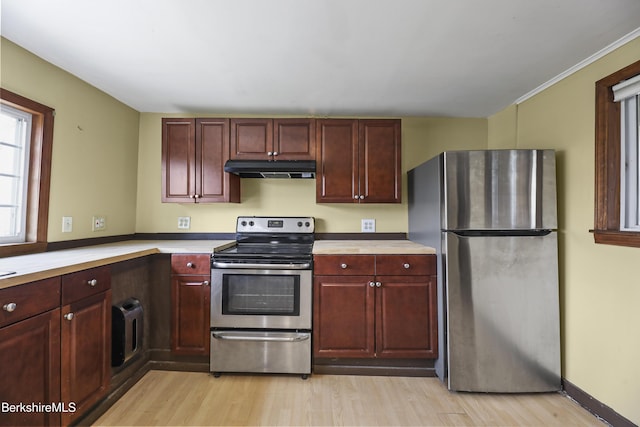 kitchen featuring light wood-style floors, under cabinet range hood, appliances with stainless steel finishes, light countertops, and dark brown cabinets