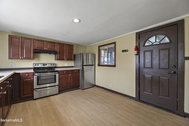 kitchen featuring stainless steel appliances, light countertops, light wood-style flooring, and under cabinet range hood