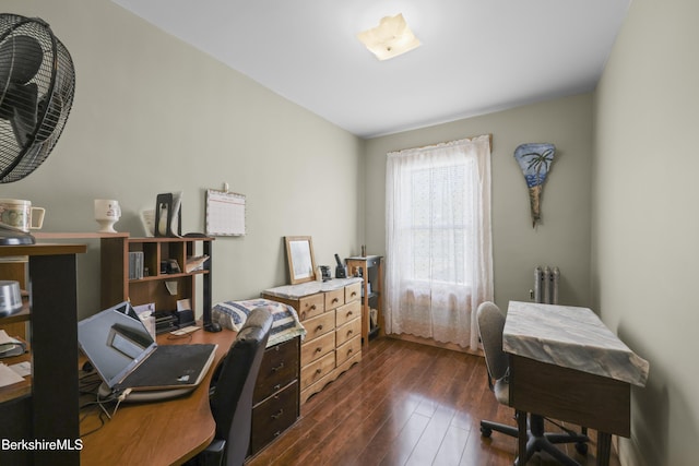 home office with radiator heating unit and dark wood-type flooring