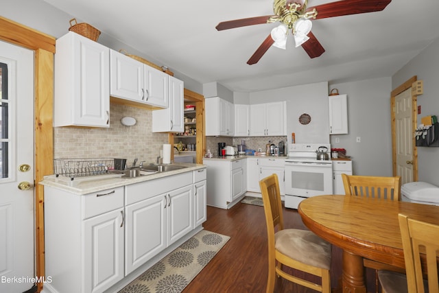 kitchen featuring ceiling fan, white electric range, tasteful backsplash, a sink, and dark wood finished floors