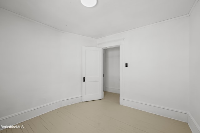 empty room featuring baseboards and light wood-type flooring