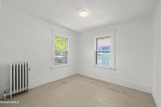 unfurnished room featuring baseboards and radiator