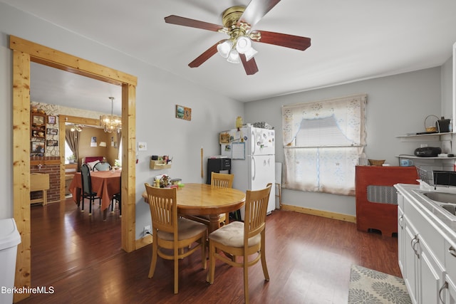 dining space with ceiling fan with notable chandelier and wood finished floors