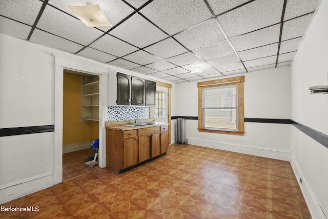 kitchen featuring light countertops, baseboards, and a sink