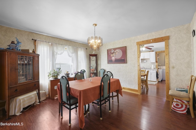 dining area with an inviting chandelier, dark wood-style flooring, and wallpapered walls