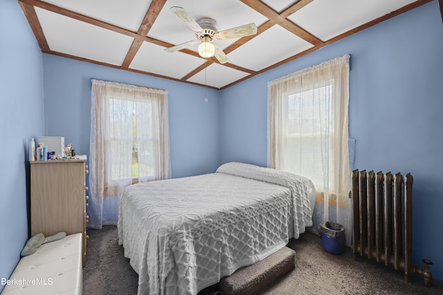 carpeted bedroom with a ceiling fan, coffered ceiling, and radiator heating unit