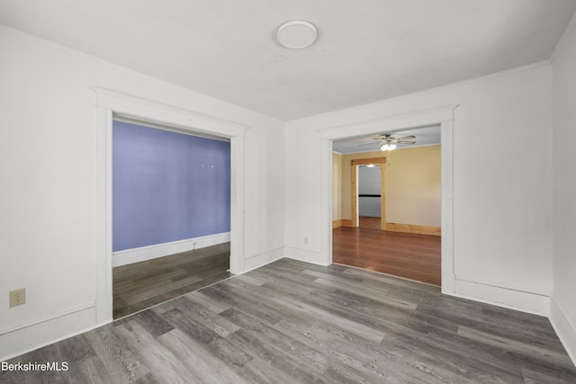 empty room featuring baseboards, ceiling fan, and wood finished floors